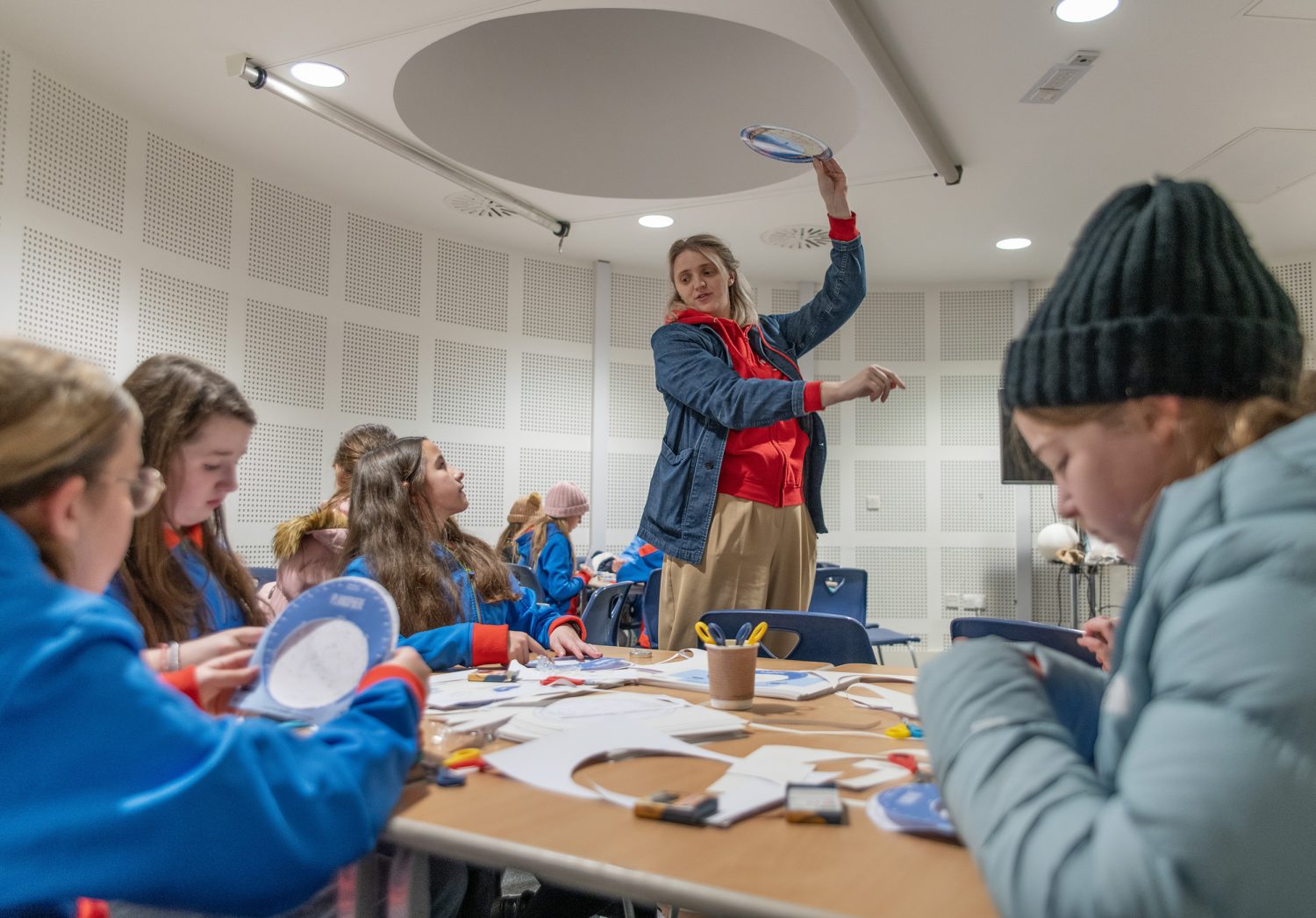 A photo of a group of girl guides being led in a paper crafting exercise,