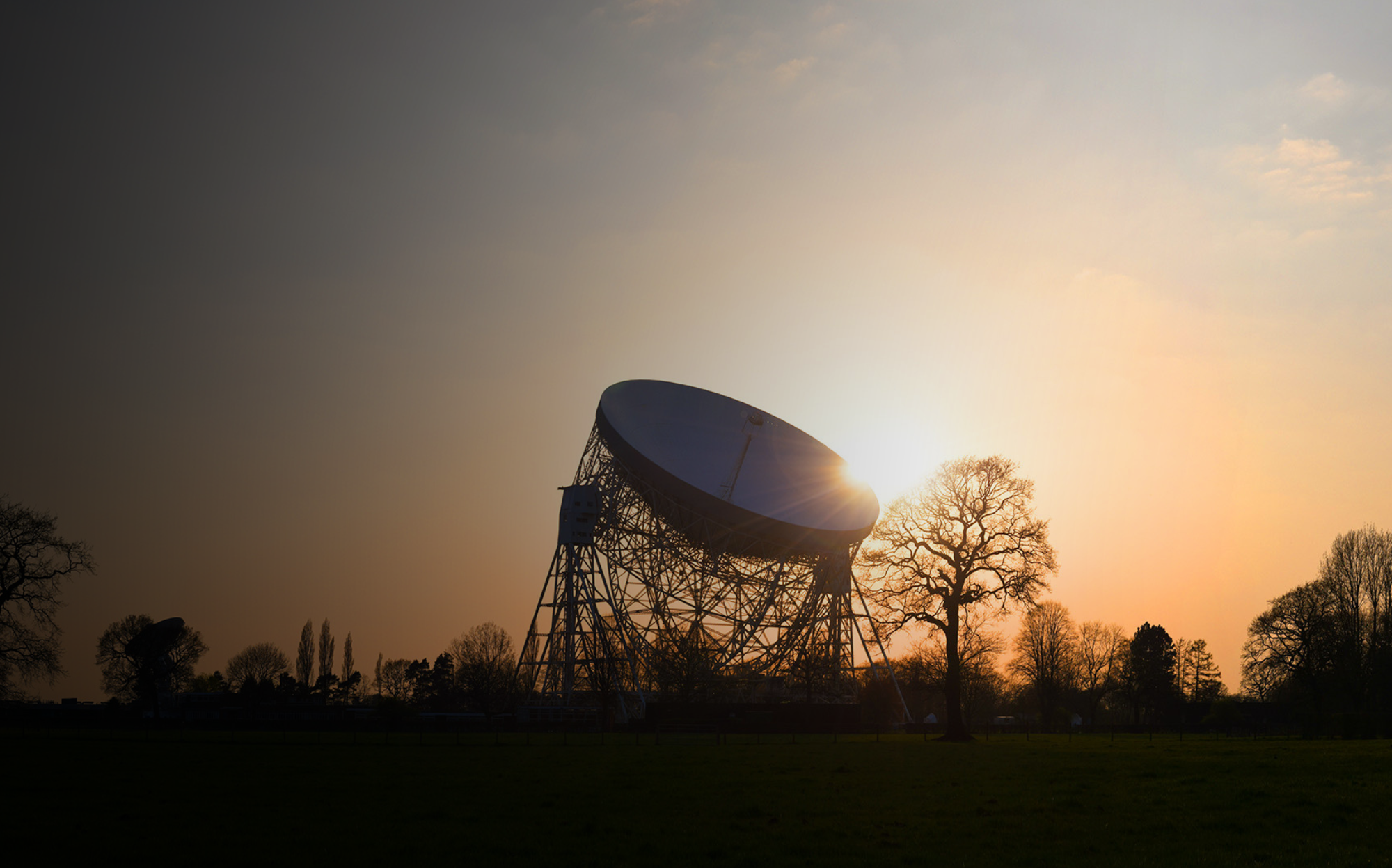 A photo of the Lovell silhouetted on the horizon at dusk.