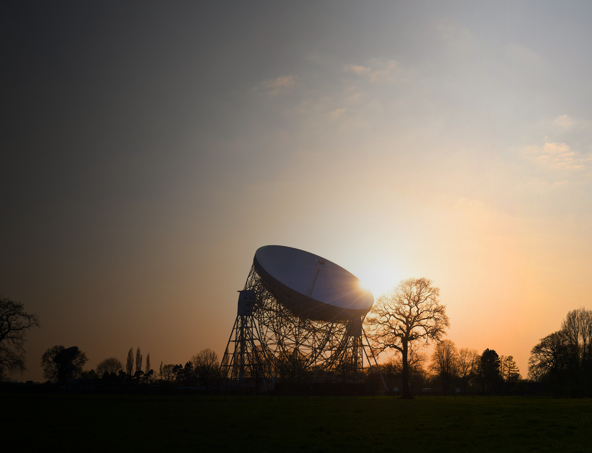 A photo of the Lovell silhouetted on the horizon at dusk.