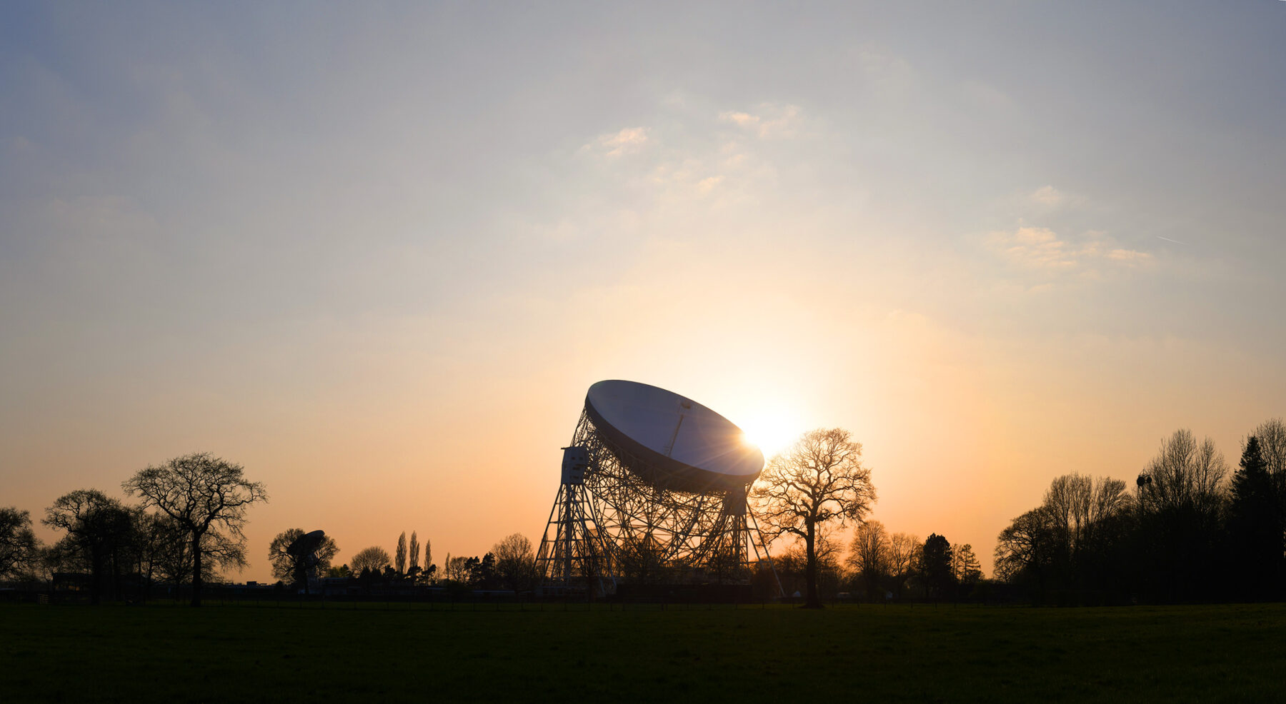 A photo of the Lovell silhouetted on the horizon at dusk.
