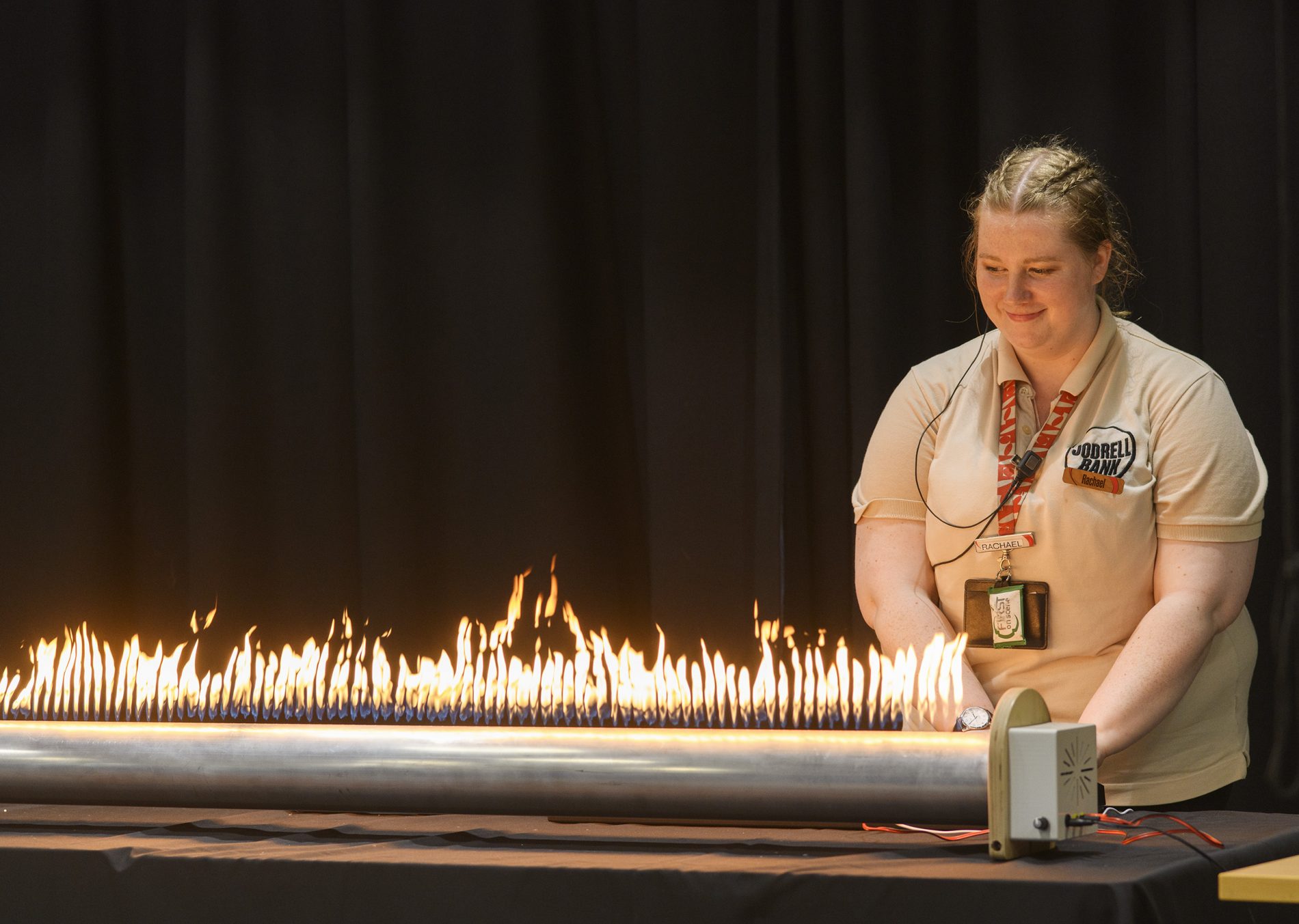 An explainer stands behind a fiery science demonstration.