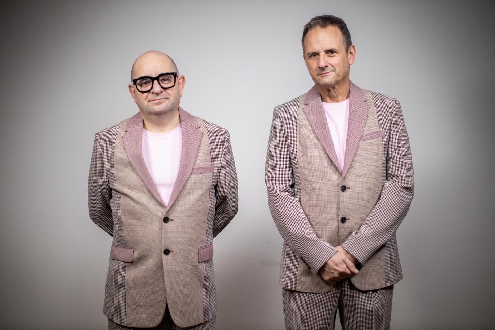 UNE members, Paul Langley and Mark Radcliffe standing side by side