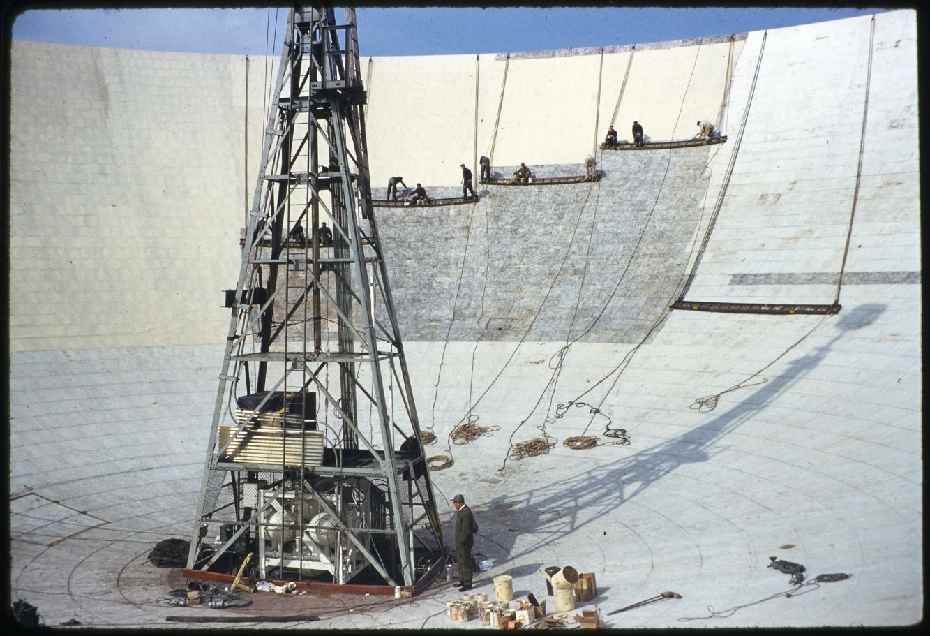 A group of workers suspended on the Lovell Telescope and painting the dish