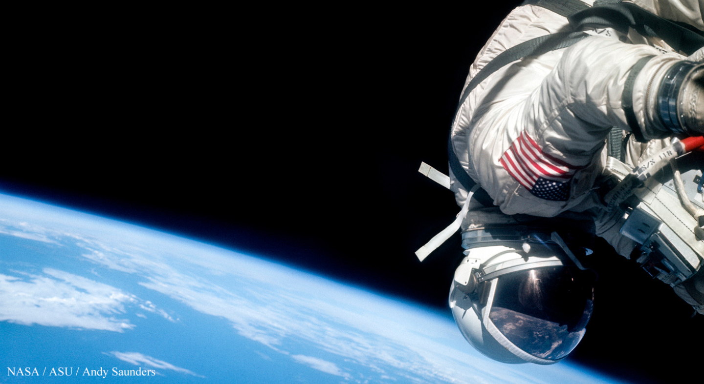 A photo of an astronaut suspended above planet Earth.